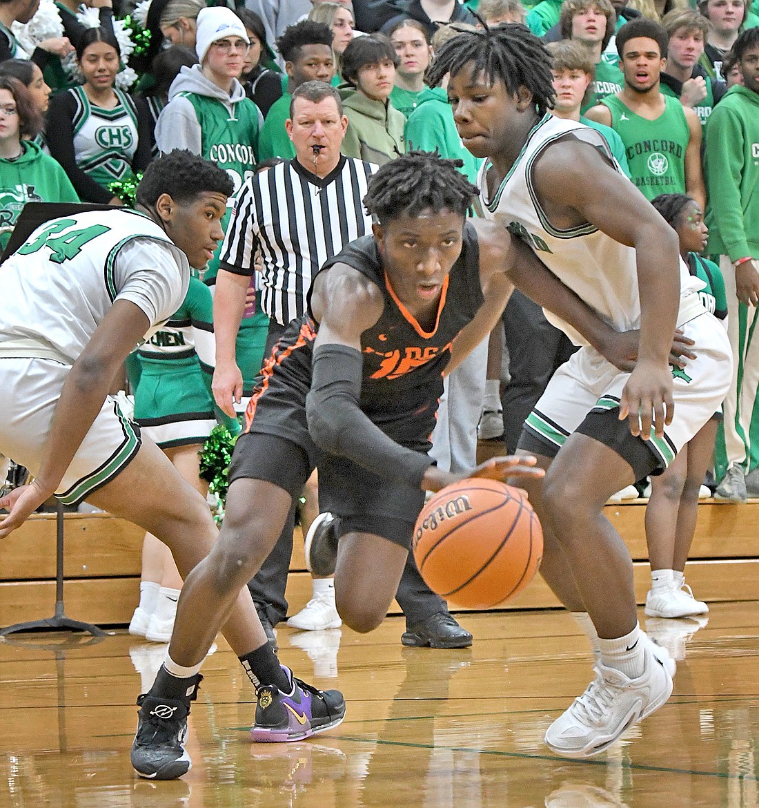 Warsaw sophomore Mydin Burgher finds his way between a pair of Concord defenders during the first quarter. Photo by Gary Nieter