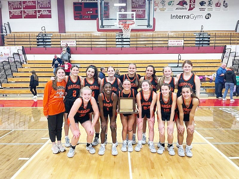 The Warsaw girls basketball team holds up its trophy after winning its third straight Northern Lakes Conference championship with a win against Goshen on Tuesday. Warsaw has won its last 22 regular season NLC games. Photo provided by Warsaw Tigers