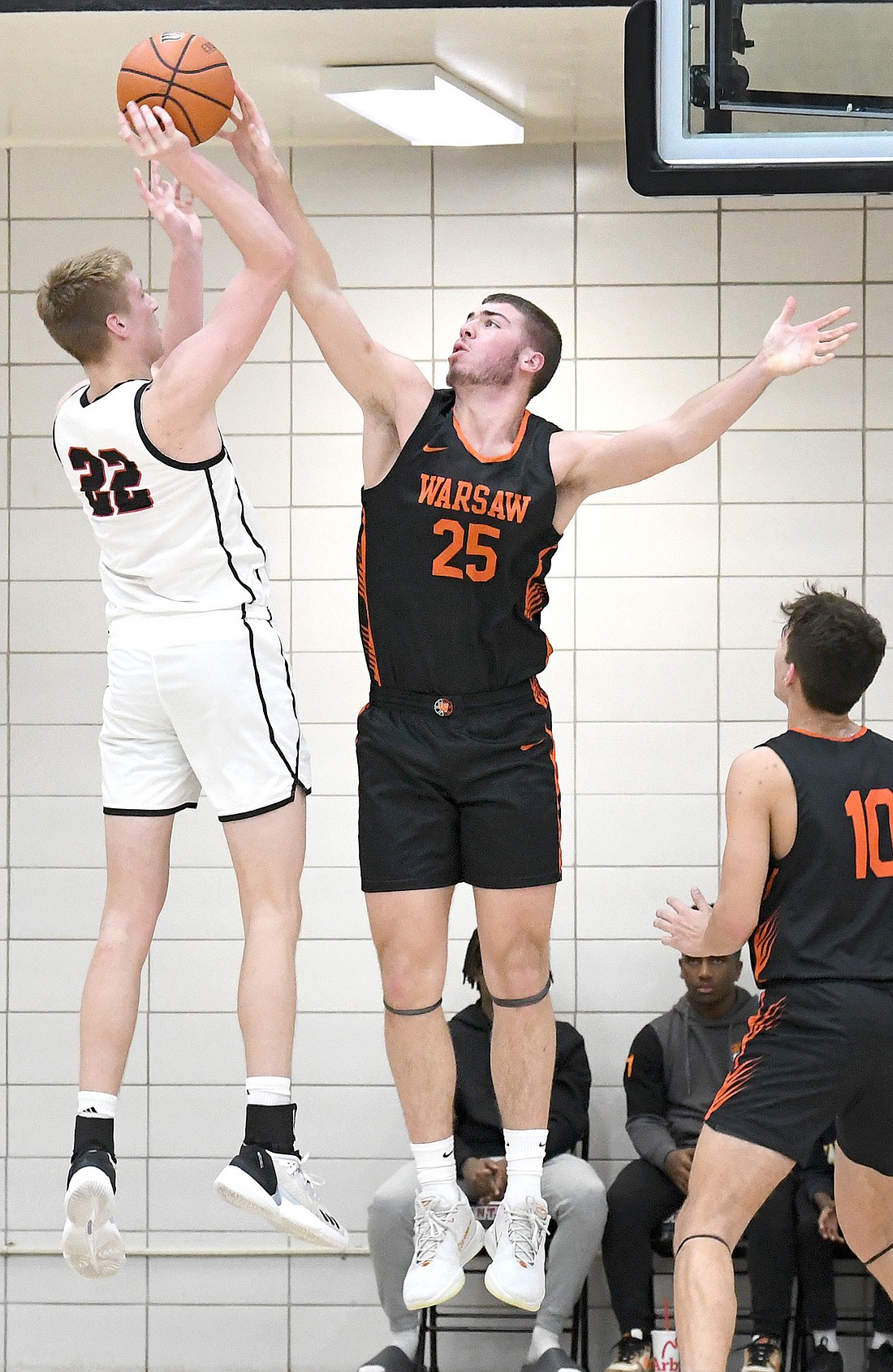 Senior Luke Yeager of Warsaw uses all of his 6'8" frame to block the shot of NorthWood's 6'8" Tyler Raasch. Photo by Gary Nieter