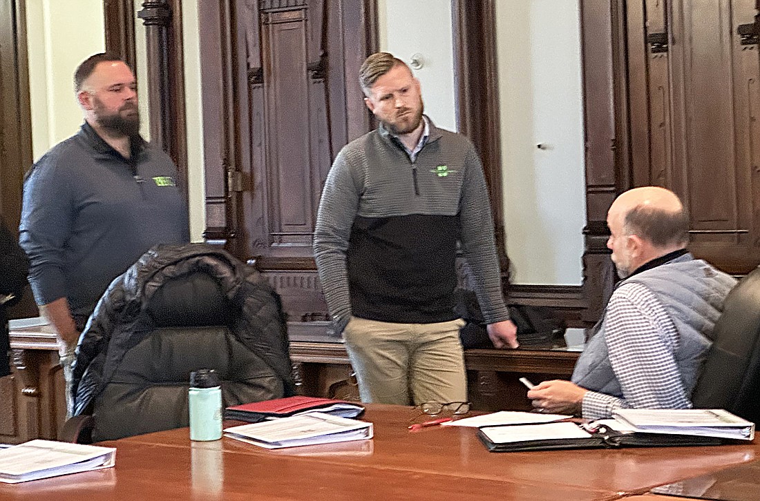 Kosciusko County Commissioner Cary Groninger (R, seated) talks to Branden Robbins (L, standing) and Matt Frische, (R, standing) from Reedy Financial Group Tuesday after the joint meeting of the County Commissioners and Council. Photo by David Slone, Times-Union