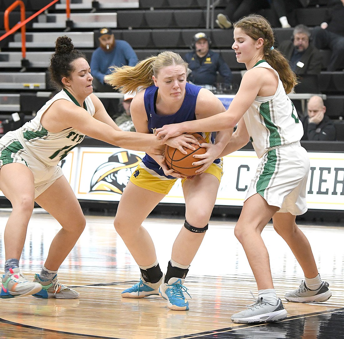 Triton senior Addyson Viers gets tied up by Trinity defenders while working in the lane during the first quarter. Photo by Gary Nieter