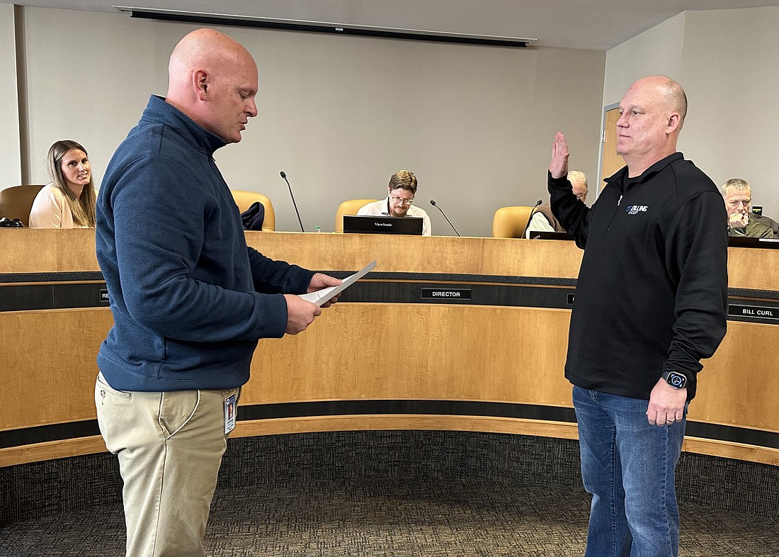 Warsaw Mayor Jeff Grose (L) gives Brad Johnson the oath of office for the Warsaw Redevelopment Commission on Monday. Photo by David Slone, Times-Union