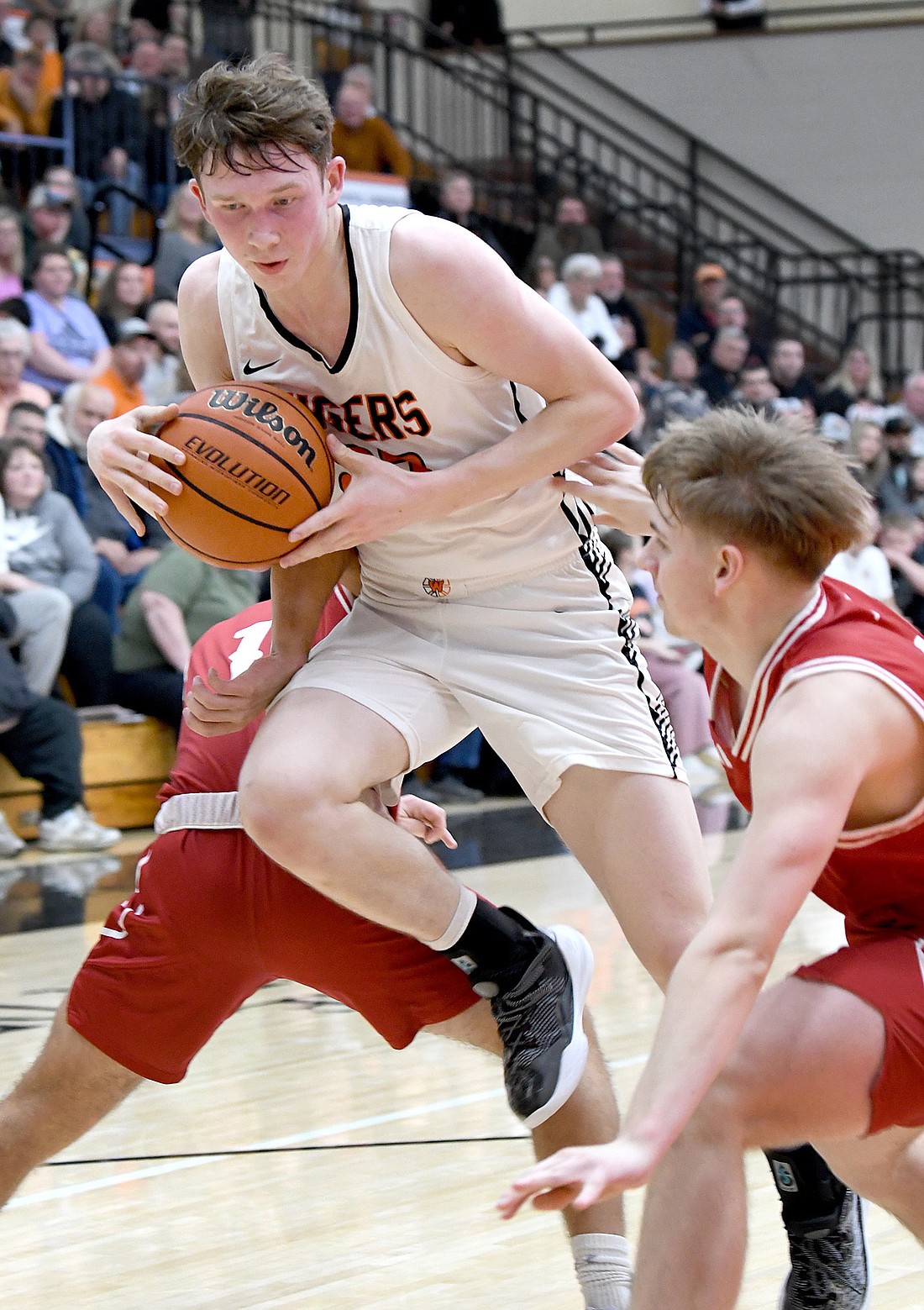 Warsaw junior Brandt Martin works his way to the basket between a pair of Plymouth defenders during the second quarter. Photo by Gary Nieter