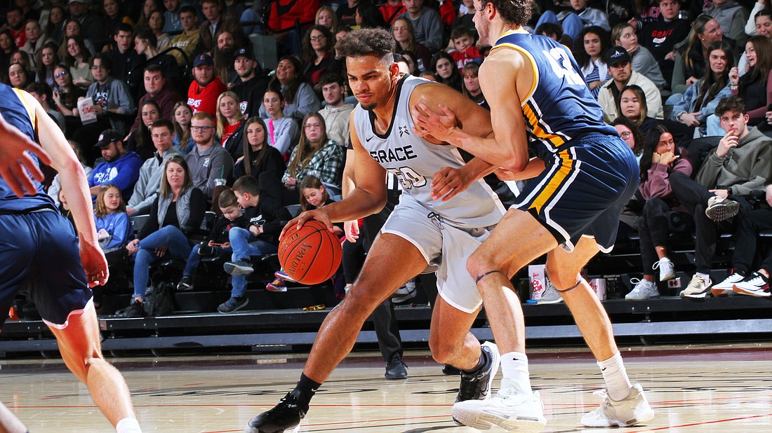 Pictured is Elijah Malone driving with the basketball for the Lancers