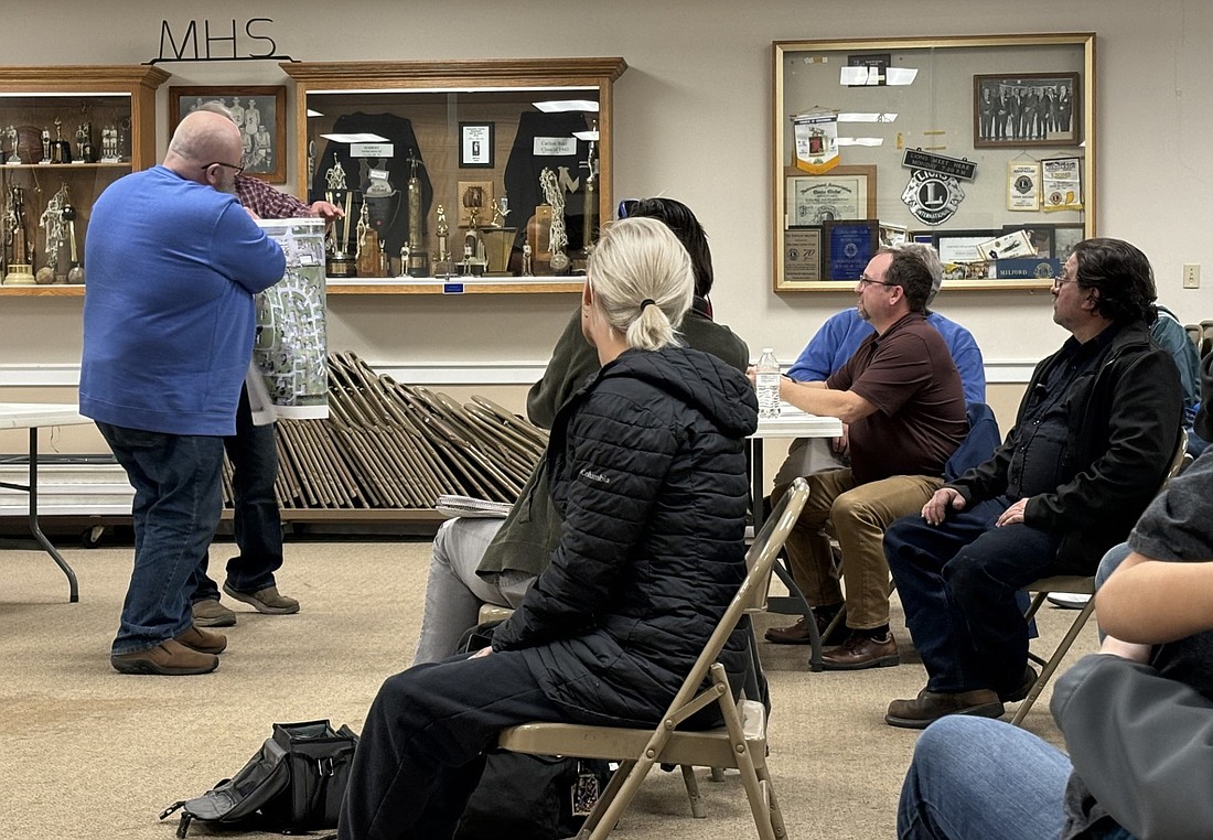 To clear up confusion of the North Park subdivision residents who showed up in large numbers at the Milford Town Council meeting Monday, Council members Ken Long (in blue) and Doug Ruch (partially hidden) showed them which homes in the development were the town’s immediate concern for removing items out of the easement. Photo by Denise Fedorow