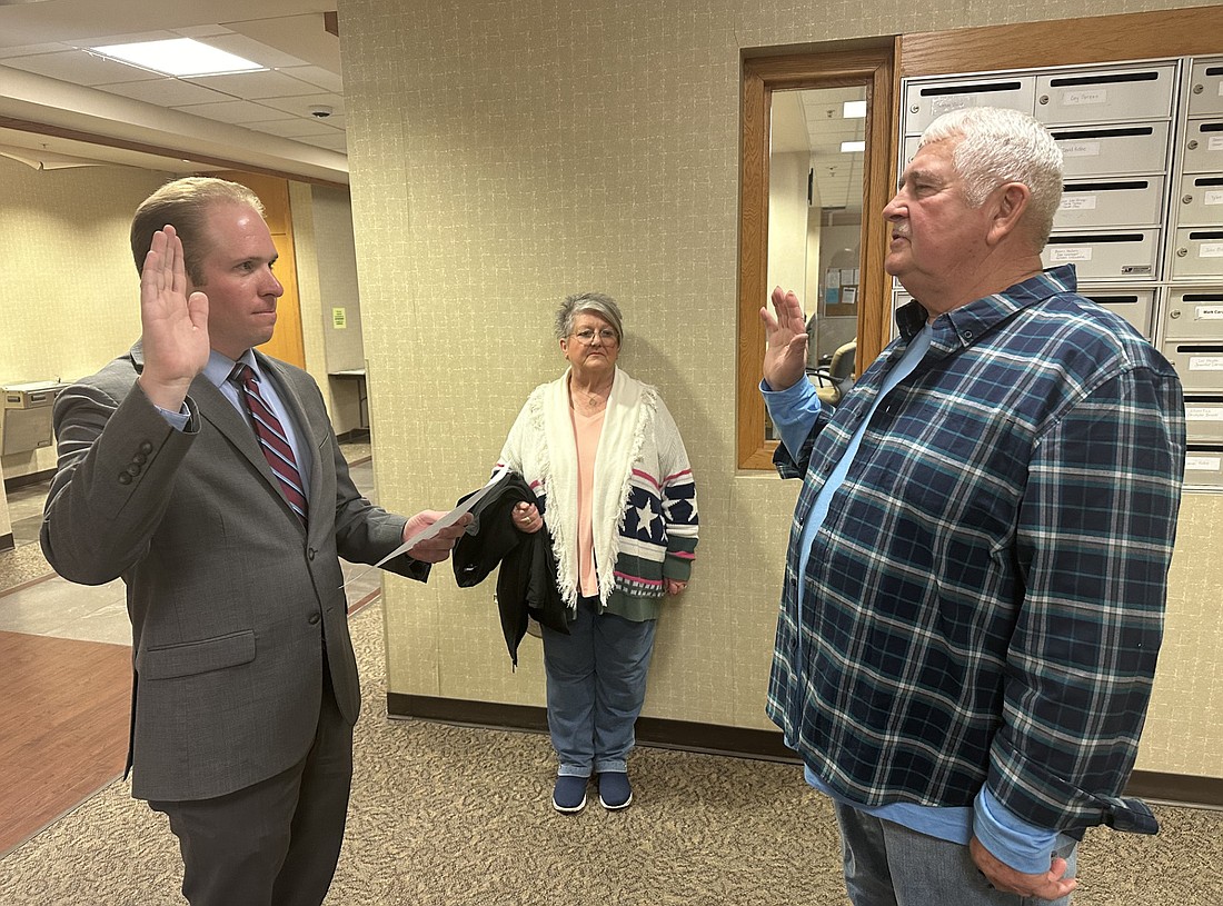 Kosciusko County Republican Party Central Committee Secretary Austin Rovenstine (L) gives the oath of office to Don Miller (R) Wednesday at the county clerk’s office as Don’s wife Vicki looks on. Miller was appointed to the Claypool Town Board middle district by Republican Party Chair Mike Ragan (not pictured). Photo by David Slone, Times-Union