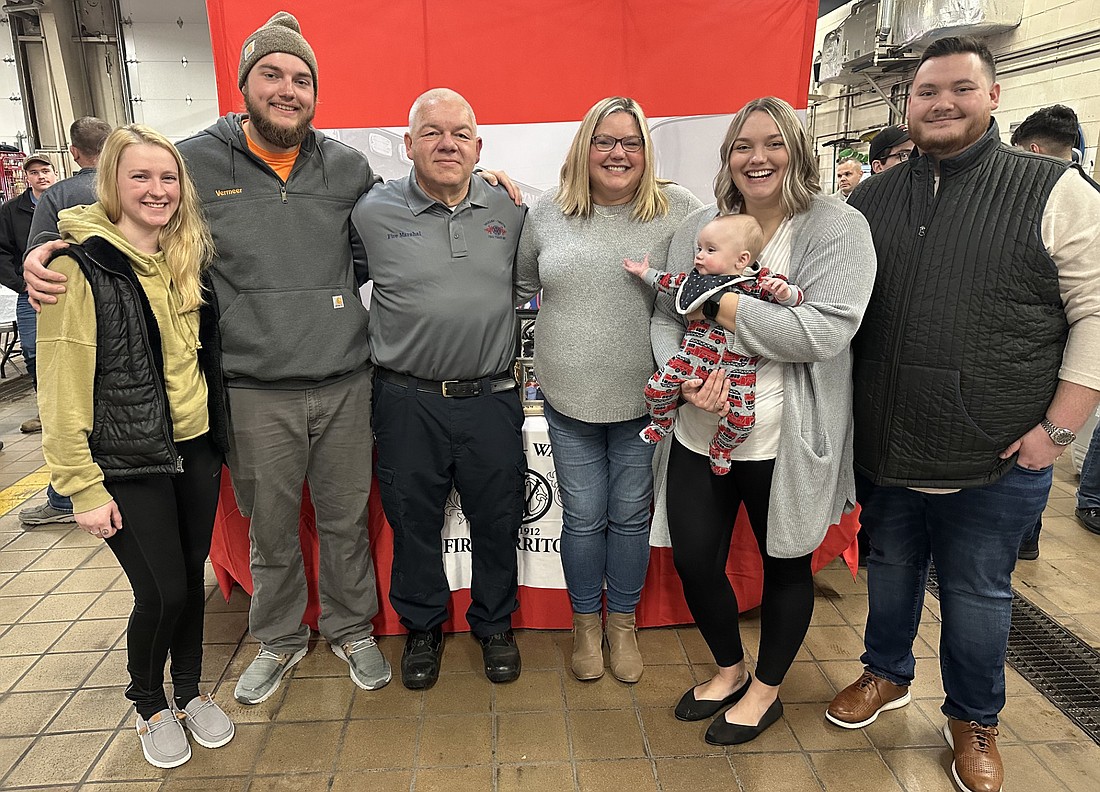 Fire Marshal Joe Fretz (C) poses for a picture with his family Friday during his retirement open house at the Warsaw-Wayne Fire Territory fire station on East Center Street. Pictured (L to R) are Jena Jordan, Brayton Fretz, Joe Fretz, Amanda Fretz, Meghan DeMaa holding Jasper DeMaa and Logan DeMaa. Photo by David Slone, Times-Union