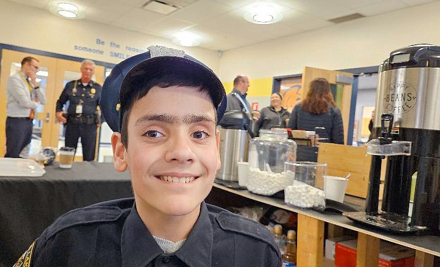 Israel Gagnon is seen behind the coffee counter at Jefferson Elementary. He chose to wear his beloved police uniform Friday on the final day of sales for a fundraiser that will help pay for a new wheelchair that he needs. Photo by Dan Spalding, News Now Warsaw