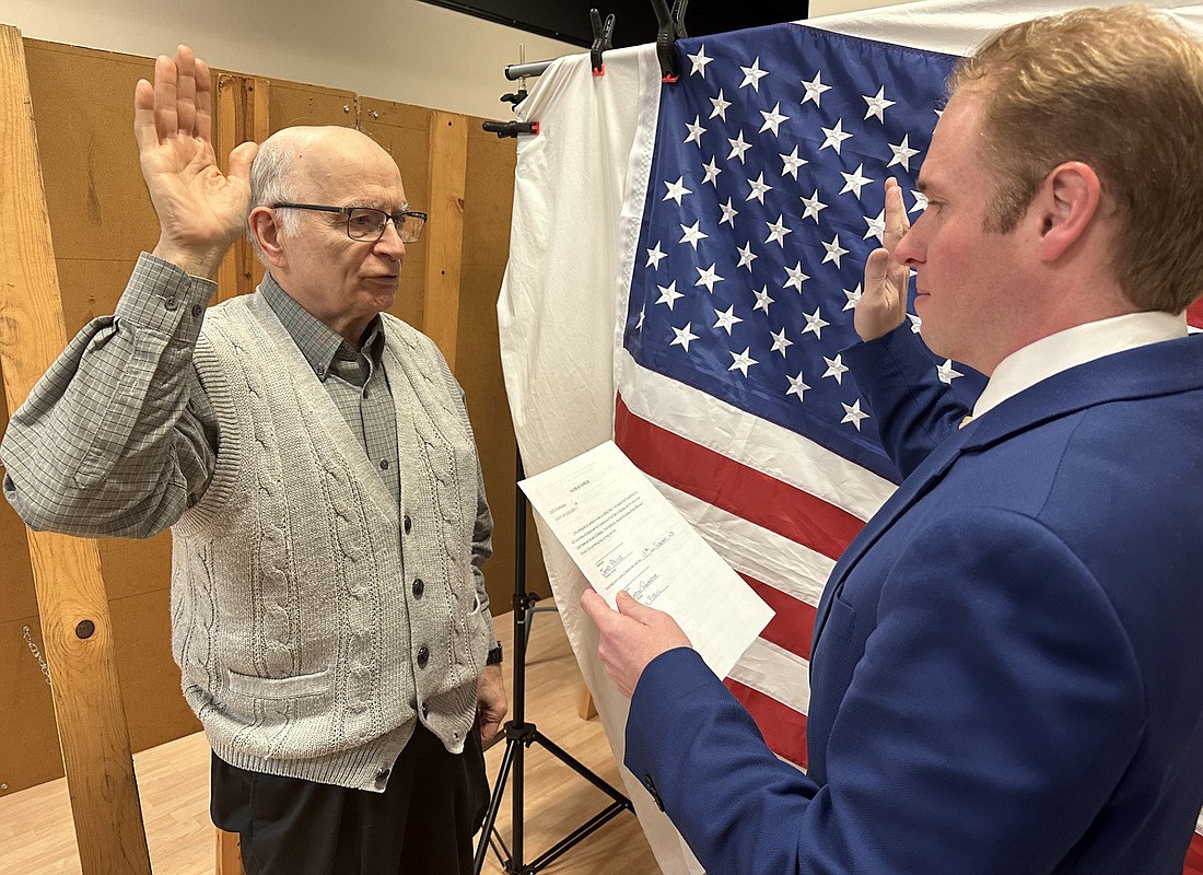 Kosciusko County Republican Central Committee Secretary Austin Rovenstine (R) gives James Pecsi (L) the oath of office Monday as the new member of the Jefferson Township Advisory Board. Pecsi was selected by a Republican caucus over Amanda Jackson to fill the seat vacated by the resignation of Robert “Bob” Riley. Photo by David Slone, Times-Union