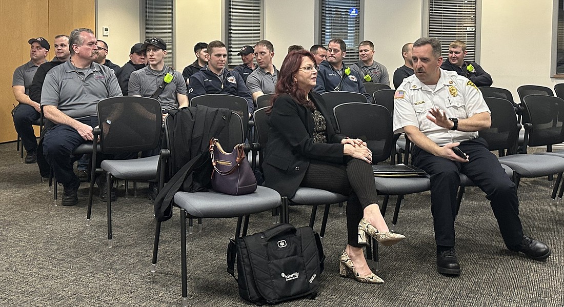 Warsaw-Wayne Fire Territory Chief Brian Mayo (front row, R) speaks to Paige Sansone, of Baker Tilly, before Tuesday’s Warsaw Common Council meeting. Sitting behind them are firefighters and EMTs from the fire territory. Photo by David Slone, Times-Union