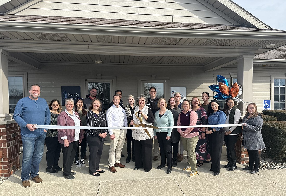 Dianne May (C), president and CEO of Cancer Services of Northeast Indiana, cuts the ribbon Wednesday during the ribbon-cutting ceremony with the Kosciusko Chamber of Commerce. Pictured with her are Cancer Services staff and Chamber ambassadors. Photo by David Slone, Times-Union