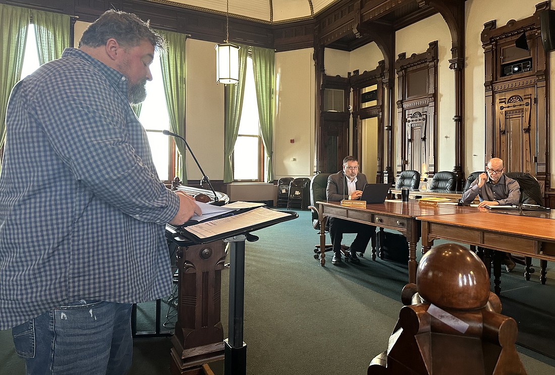 Kosciusko County Highway Department Superintendent Steve Moriarty (L, standing) presents his recommendations to the county commissioners for awarding bids for Community Crossings Matching Grant projects. Also pictured (seating, L to R) are county attorney Ed Ormsby and Commissioner Cary Groninger. Photo by David Slone, Times-Union