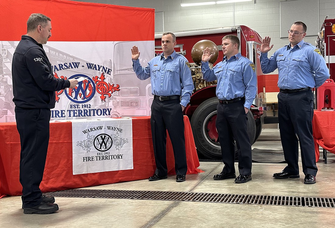 As part of a promotion ceremony, Warsaw-Wayne Fire Territory Chief Brian Mayo (L) swears in Capt. Drew Shilling, Lt. Brandon Allen and Lt. Max Kinsey on Wednesday. Photo by David Slone, Times-Union