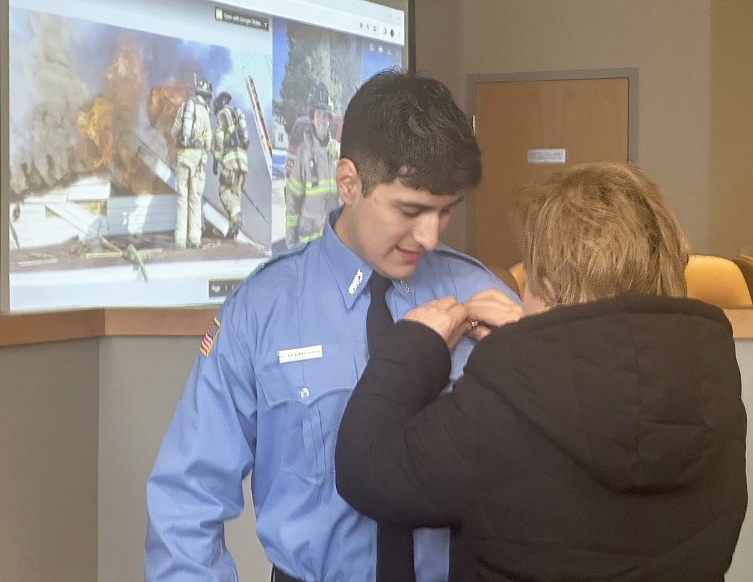 Warsaw-Wayne Fire Territory firefighter Kevin Terrazas has his badge pinned on his uniform by his mother, Faviola Ruzis, after Terrazas was given the oath of office by Warsaw Mayor Jeff Grose Friday at the Board of Public Works and Safety meeting. Photo by David Slone, Times-Union