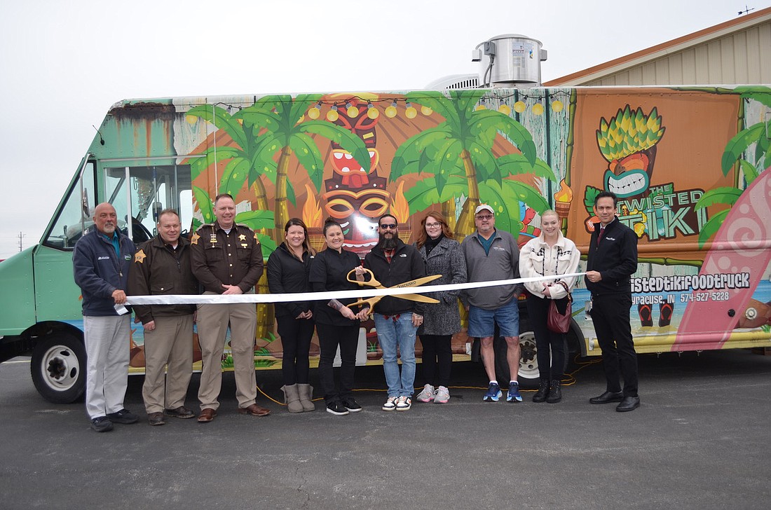 The Kosciusko Chamber of Commerce hosted a ribbon-cutting ceremony for the Twisted Tiki food truck in Leesburg. Pictured (L to R) are: Scott Wiley, Kosciusko Chamber member relations manager; Kosciusko County Sheriff’s Office Chief Deputy Chris McKeand, Chamber ambassador; Sheriff Jim Smith, Chamber ambassador; Lindsey Parker, Tippy Creek Winery; Twisted Tiki owners Michele and Micheal Camacho; Carley Meredith, Tippy Creek Winery; Daniel Richcreek, Tippy Creek Winery; Brogan Hoover, Chamber ambassador, Papa Vino's; and Andrew Balkey, Chamber ambassador, Papa Vino's. Photo by Phoebe Muthart, InkFreeNews