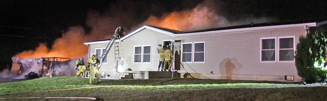 An outbuilding on the left is completely destroyed as firefighters work to save the home during Sunday's early morning blaze on CR 400E, south of CR 700S. Photo by Gary Nieter, Times-Union