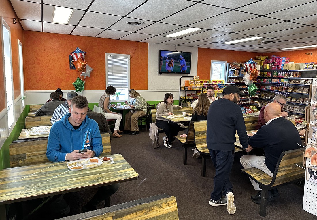 Bomy Singh (standing), owner of Bomy’s Authentic Indian Food and Groceries, 1403 E. Winona Ave., Warsaw, talks with Kosciusko Chamber of Commerce staff during the business’ anniversary luncheon Monday. Photo by David Slone, Times-Union