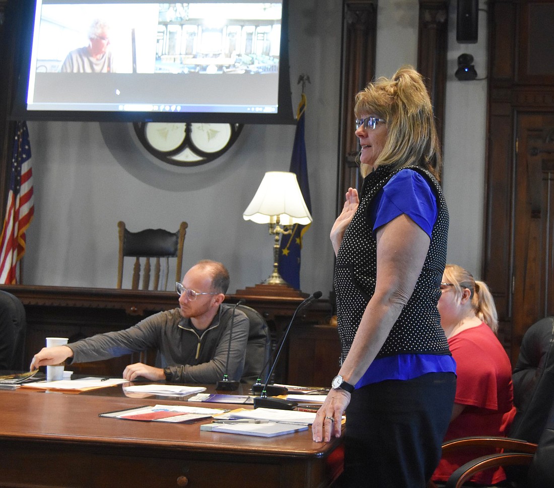 Board member Kathy Ray is sworn in at the KCCRVC meeting Wednesday. To the left is Vice President Lyle Schrock and to the right, behind Ray, is Board Member Jessica Hartman. Treasurer John Hall can be seen in the top left corner live streaming in. Photo by Patrick Webb, InkFreeNews