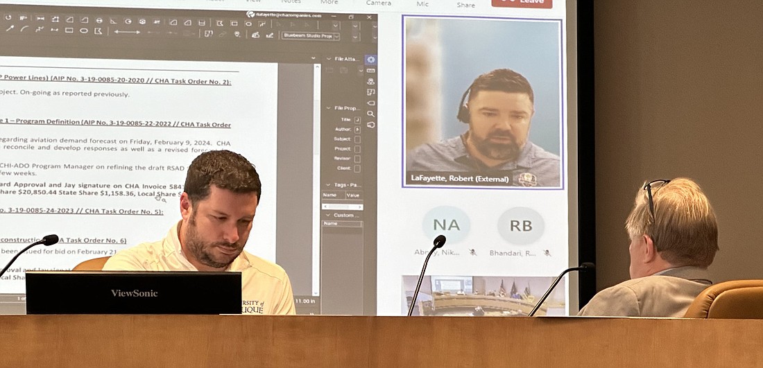 Robert LaFayette (on the screen), CHA Consulting, gives the Warsaw Board of Aviation Commissioners quick updates on projects Tuesday. Also pictured are Warsaw Municipal Airport Manager Nick King (L) and Board President Jay Rigdon (R). Photo by David Slone, Times-Union