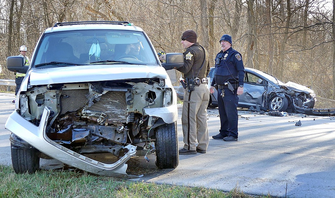 Officers talk with one of the drivers involved in Wednesday morning's head-on collision on Ind. 13 at South Barbee Drive. Photo by Gary Nieter, Times-Union