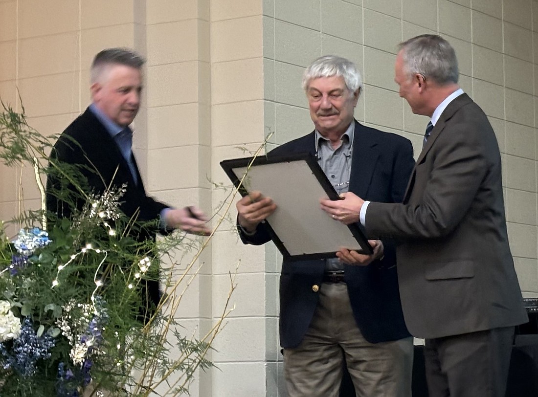 Rep. Craig Snow (R) shows the Sagamore of the Wabash Award to a surprised Larry Coplen as Chamber Board President Jeff Dyson (L) looks on. The presentation was made at the Syracuse-Wawasee Chamber of Commerce banquet Thursday. Photo by Denise Fedorow