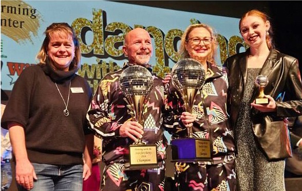 Overall winners Trace Hansen and Karri Morgan (center) hold their winning trophies while pictured with Rebecca Bazzoni (L), executive director of Joe’s Kids. At right is Victoria Peloza, the team’s choreographer. Photo by Dan Spalding, News Now Warsaw