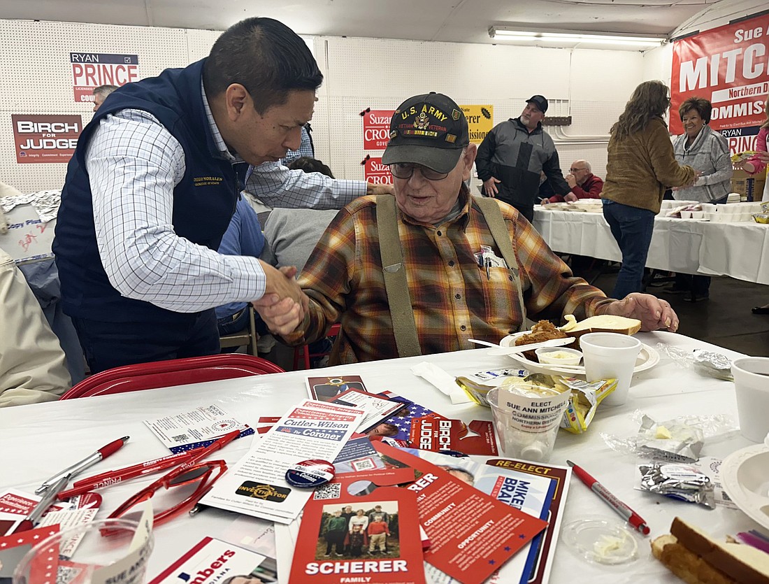Indiana Secretary of State Diego Morales (L) presents a Challenge Coin to a veteran after thanking the veteran for his service. Photo by David Slone, Times-Union