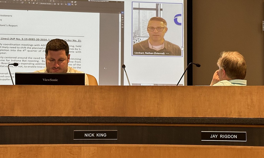 Nathan Lienhart (on screen), aviation project manager for CHA, Warsaw Municipal Airport’s engineering consulting firm, gives an update on an airport project to the Warsaw Board of Aviation Commissioners Tuesday. Shown listening are Airport Manager Nick King (L) and Board President Jay Rigdon (R). Photo by David Slone, Times-Union