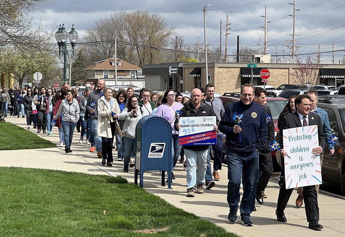 Led by Kosciusko County Prosecutor Brad Voelz (front left), people march around the courthouse square to bring awareness to Child Abuse Prevention Month, which is April. Photo by David Slone, Times-Union