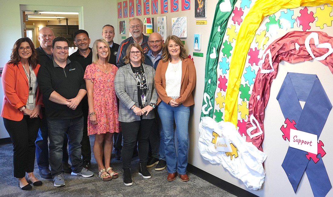 Warsaw Community Schools Superintendent Dr. David Hoffert and Director of Special Services Kelly Meeks, with Warsaw School Board members Heather Reichenbach, Randy Polston, Elle Turley, Tom Westerhof, Brad Johnson, Denny Duncan and Matt Deuel, celebrate the ARTism Awareness showcase with autism resource specialist Maria Demopoulos. Photo Provided