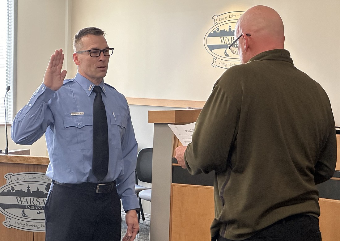 Warsaw Mayor Jeff Grose (R) gives Warsaw-Wayne Fire Territory firefighter Brandon Schmitt the ceremonial oath of office Friday during the Board of Public Works and Safety meeting. Photo by David Slone, Times-Union