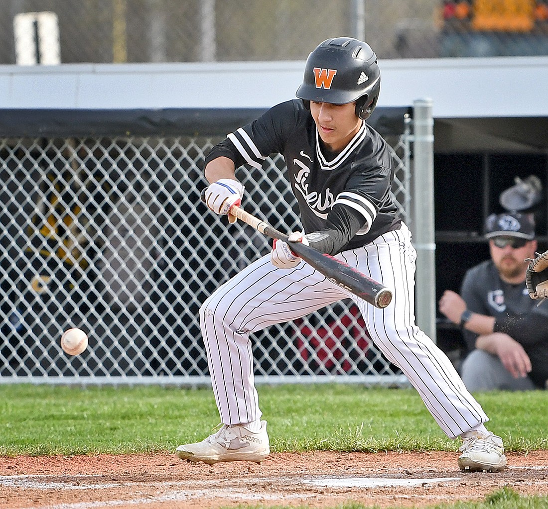 Senior Logan O'Malley of Warsaw lays down a bunt attempt during his turn at bat in the first inning. Photo by Gary Nieter