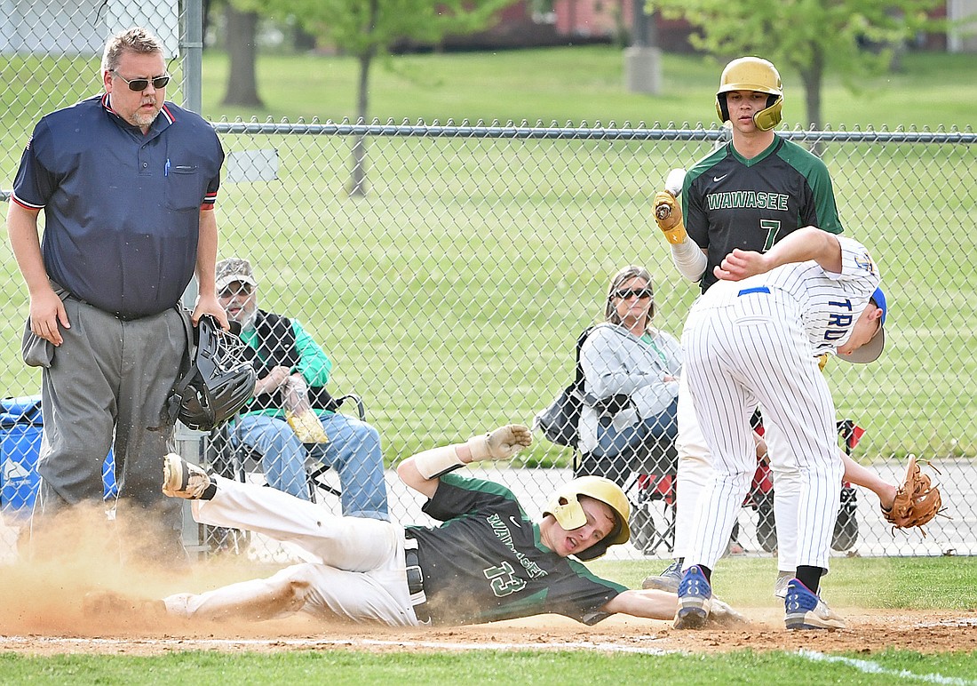 Wawasee freshman Ryan Mack reaches for the plate while sliding past the tag of Triton's Drew Bingamon to score Wawasee's fifth run of the first inning...Nieter