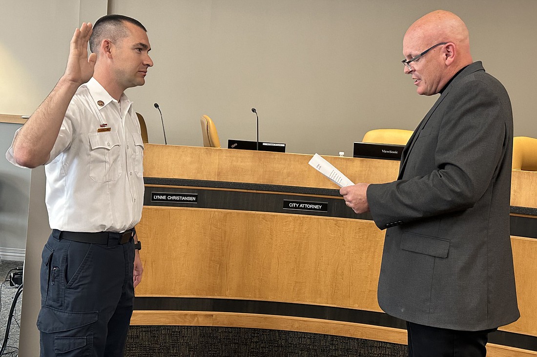 Warsaw Mayor Jeff Grose (R) gives Joel Shilling (L) the ceremonial oath of office as the new Warsaw-Wayne Fire Territory chief at Friday’s Board of Public Works and Safety meeting. Photo by David Slone, Times-Union