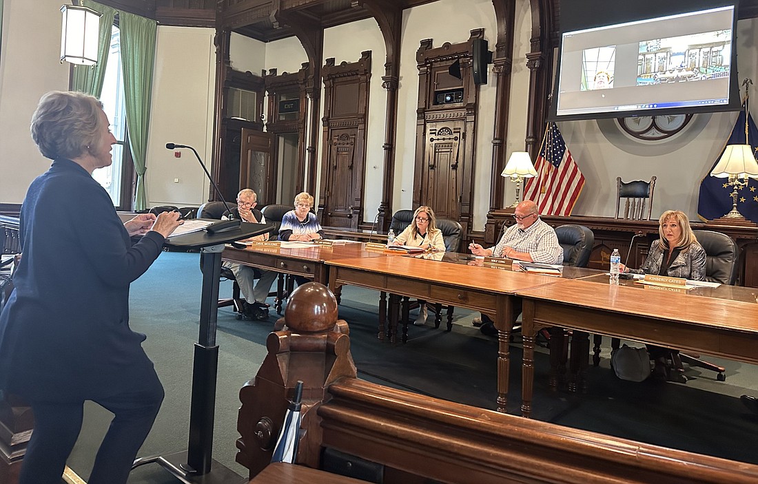 Kosciusko County Administrator Marsha McSherry (standing) gives a project update to the County Council Thursday. Pictured (L to R), seated, are Council members Dave Wolkins, Sue Ann Mitchell, Kathleen Groninger, Mike Long and Kimberly Cates. Councilwoman Joni Truex is seen on the screen above, attending the meeting virtually. Councilman Tony Ciriello is not pictured. Photo by David Slone, Times-Union