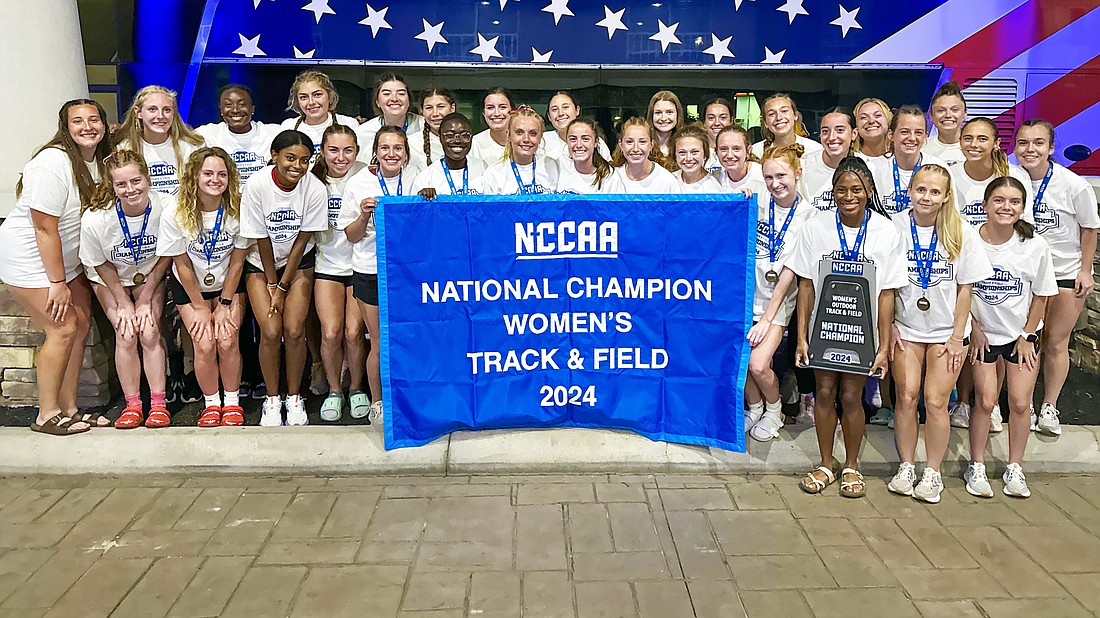 Pictured is Grace's women's track and field team with their 2024 NCCAA national championship banner.