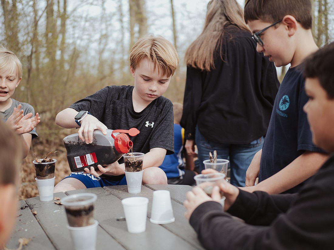 Students create a model wetland and observe the positive impact wetlands have on water quality in local lakes. Photo Provided