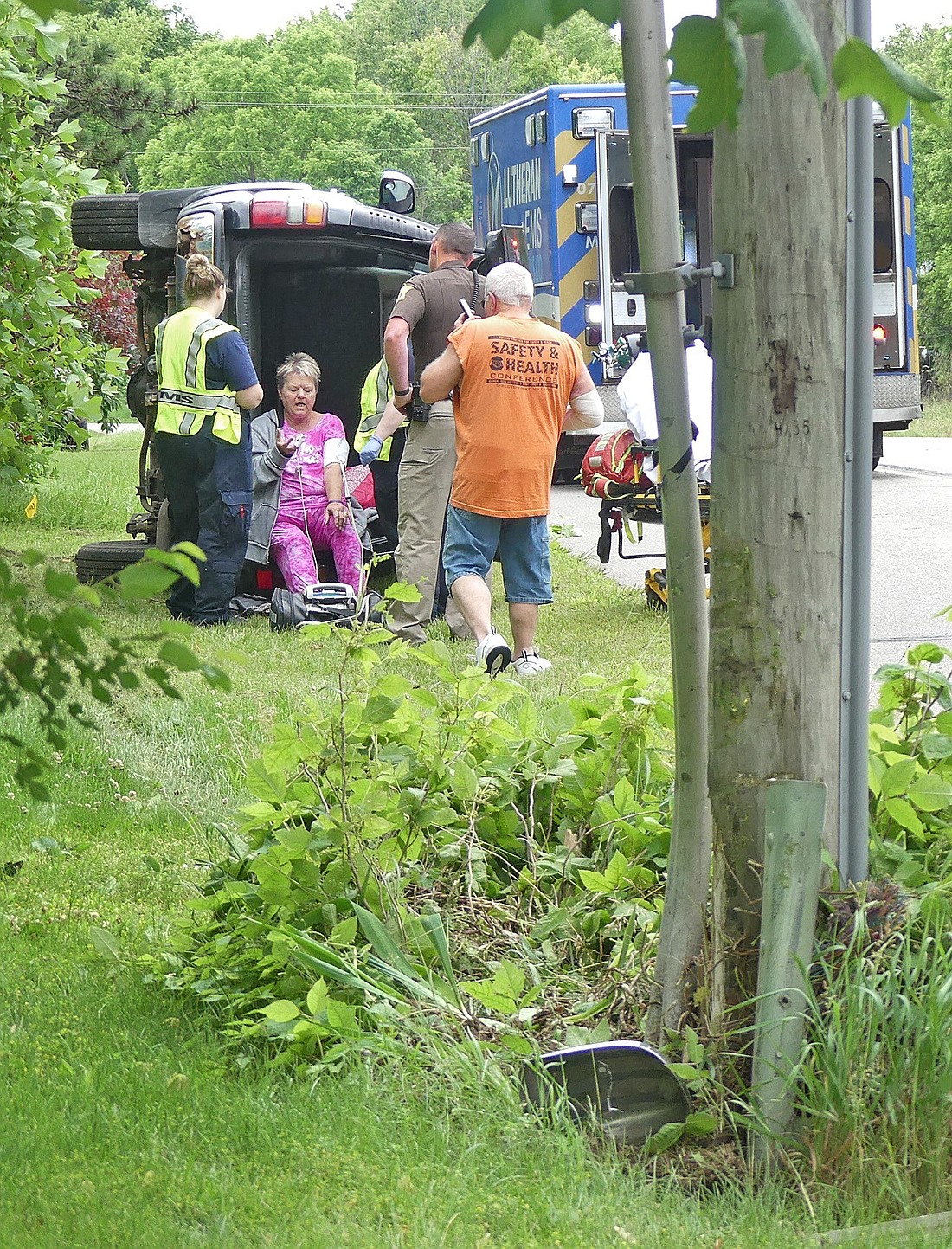 Medics tend to the accident victim Wednesday morning after the vehicle rolled on its side after clipping a utility pole on Old Ind. 15, north of Levi Lee Road. Photo by Gary Nieter, Times-Union.