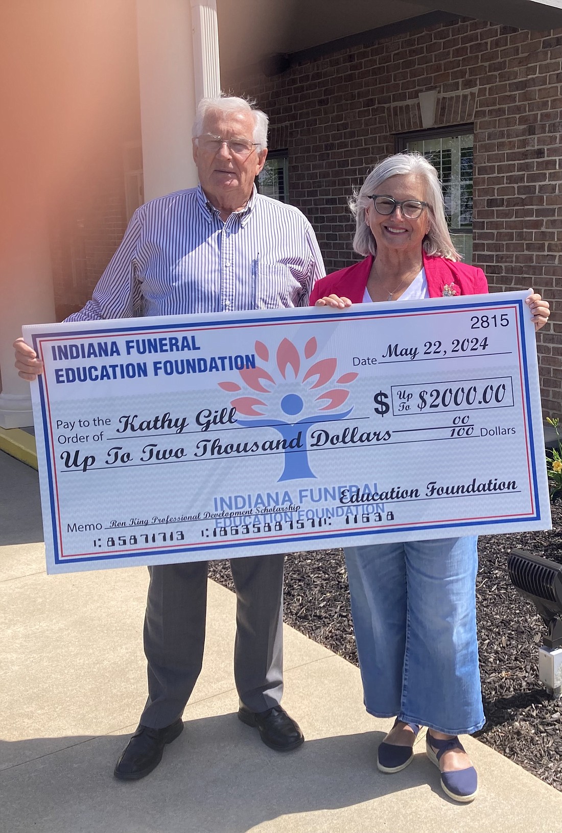 Pictured are Ron Redpath, owner of Redpath-Fruth Funeral Home, and Kathy Gill of Redpath-Fruth with her $2,000 replica scholarship check. Photo by Paul Smith, Times-Union.