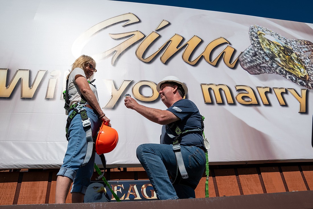 Dan Walcott proposed to Gina McCray Friday on the ledge of a billboard off U.S. 30. The billboard says: “Gina, will you marry me?” Photo provided by Daniel Holderman Photography