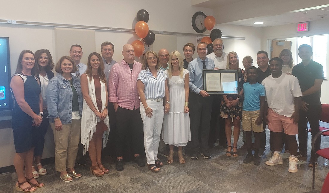 Warsaw Community Schools Superintendent Dr. David Hoffert (with framed resolution) poses with WCS administration members, Warsaw School Board and his family Tuesday. Photo by Jackie Gorski, Times-Union