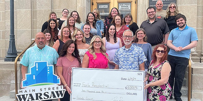 Forte Residential Inc. in Warsaw received a $10,000 facade grant from Main Street Warsaw. Pictured are Forte's staff and Main Street Warsaw Supporter Relations Manager Scott Wiley. Photo by Liz Adkins, InkFreeNews