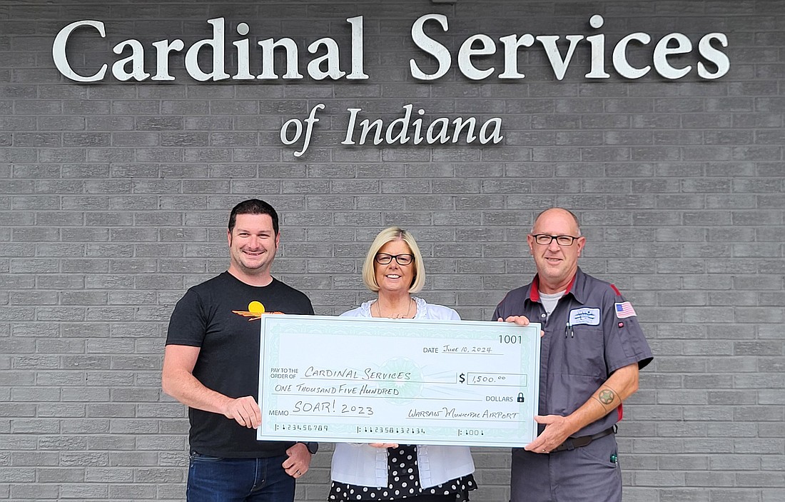 Cardinal Services Executive Director Vickie Lootens (C) is flanked by Airport Manager Nick King (L) and Airport Line Manager Ray Scott (R) as they present the donation from SOAR 2023. Photo Provided.