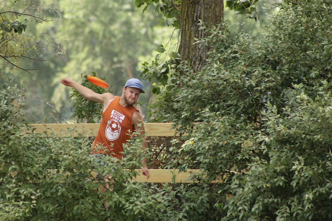 Alaister McFarren, who manages Circle Disc Golf in Winona Lake, throws from the course's elevated platform on hole 2. Photo by Claire Sprankle