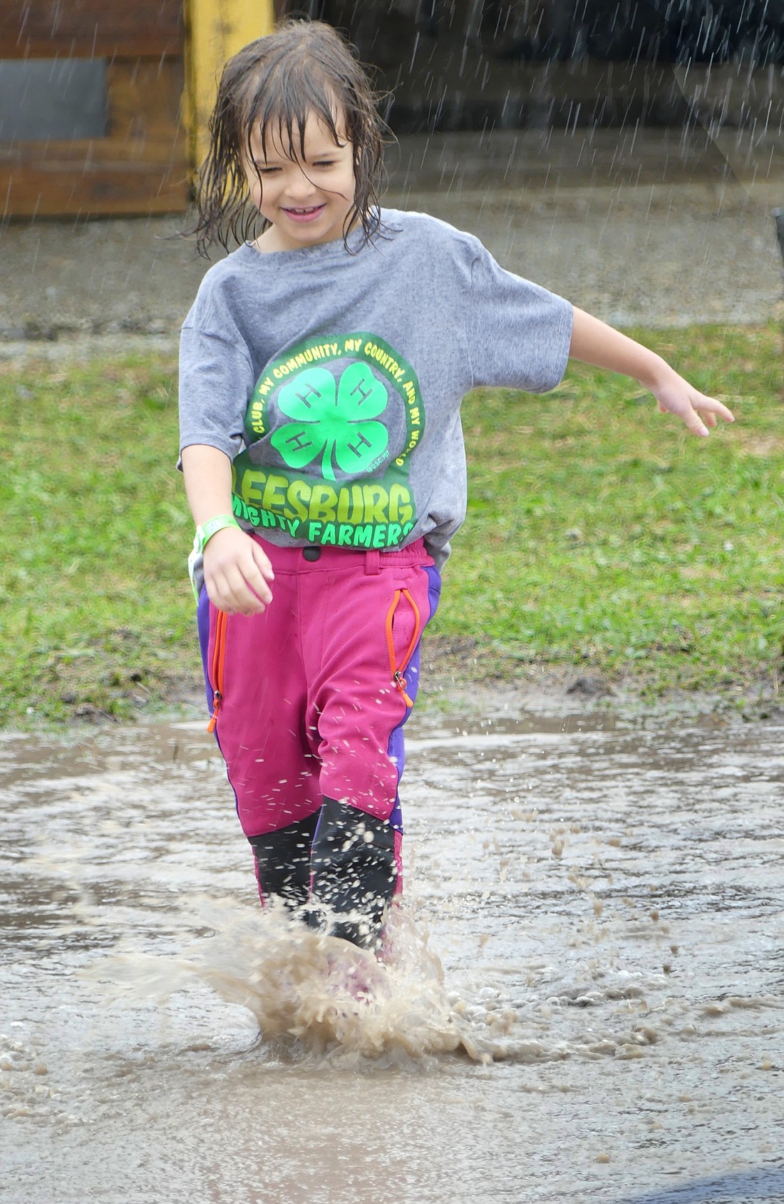 Although the rain put a damper on a lot of Wednesday morning’s fair activities, Clara Flores makes the most of the situation while running between barns at the fairgrounds. Photo by Gary Nieter, Times-Union