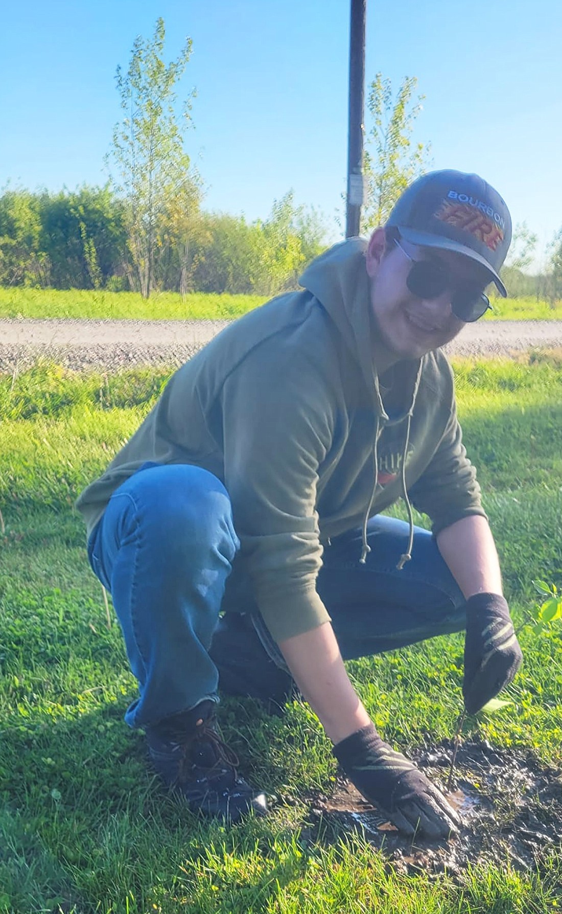 Alex Gaughan plants a tree at Potawatomi Wildlife Park's "tree planting party" community event in May. Photo Provided.