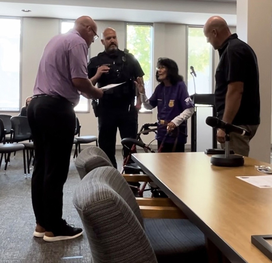 Warsaw Mayor Jeff Grose (L) gives Patricia Strombeck the oath of office while her grandson, Warsaw Police Department officer Chris Francis (to her right) and WPD Chief Scott Whitaker (R) stand in support. Photo provided.