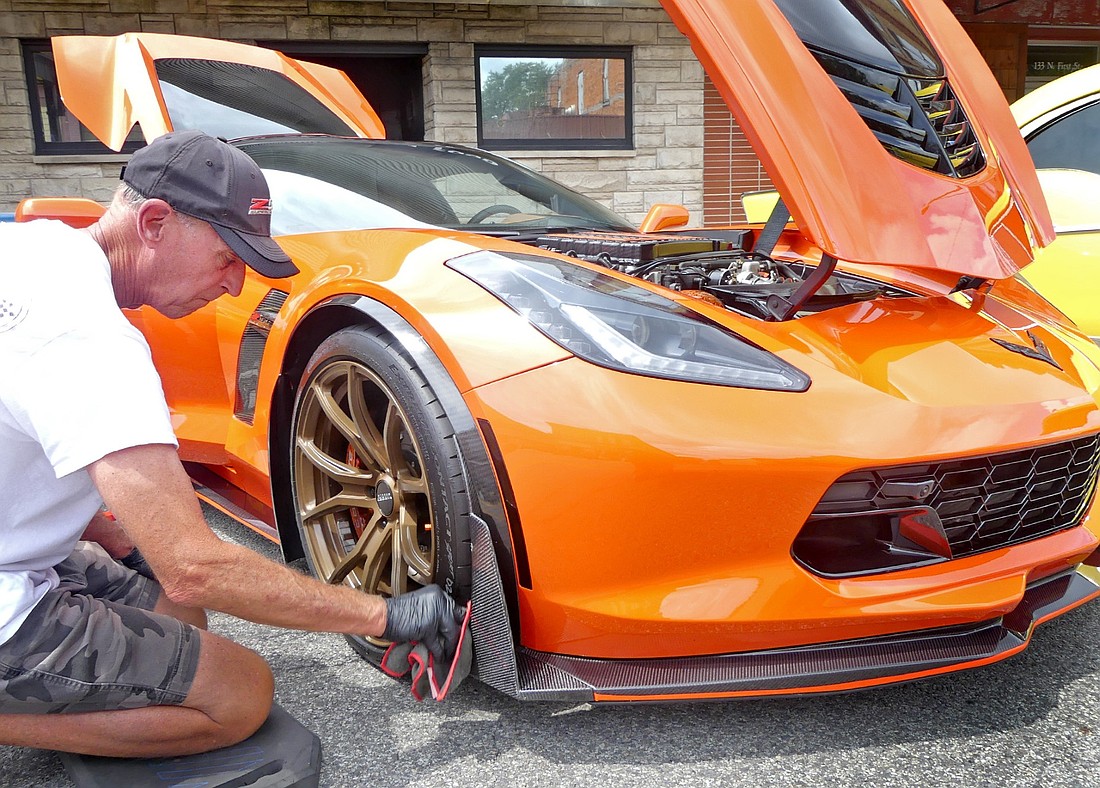 Andy Green of Warsaw spruces up his 2019 Chevrolet Corvette ZO6 for Pierceton's annual car show Friday evening. Photo by Gary Nieter, Times-Union