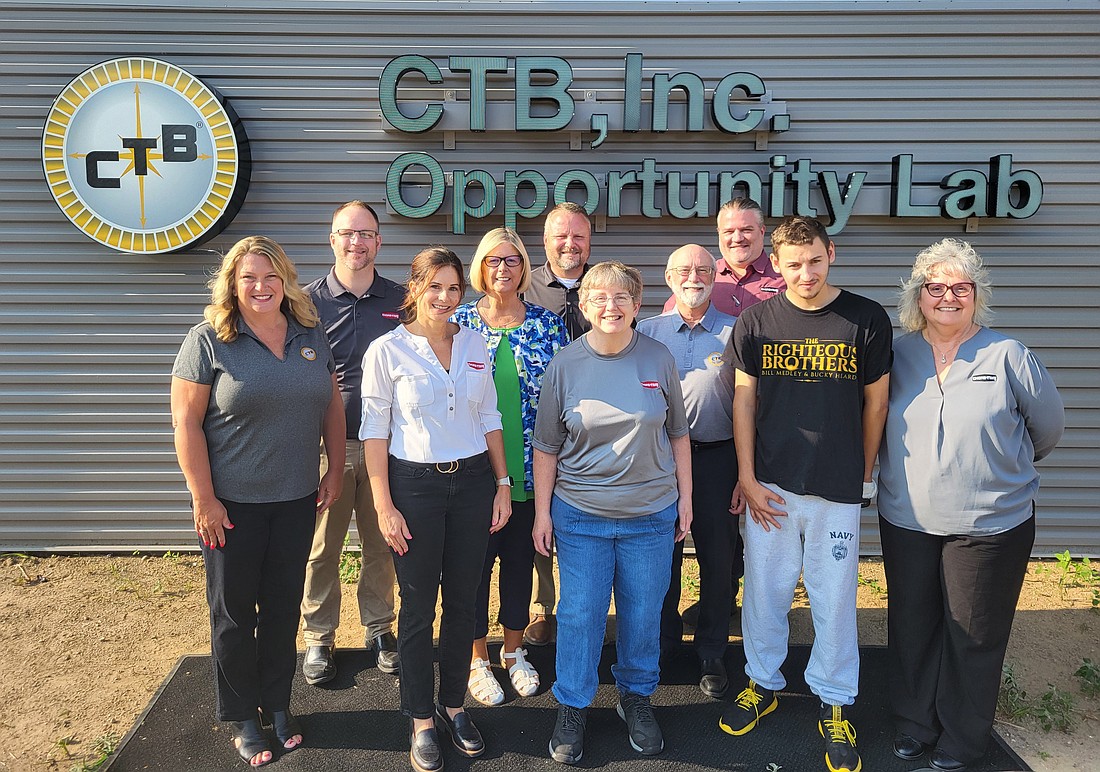 Representatives of CTB and Cardinal gather in front of the new CTB Inc. Opportunity Lab sign at Cardinal Services. Pictured (L to R) are, front row: Mindy Brooks, Tina Streit, Sandy Bibler, Jack Deeter, Jo Coverstone; middle row: Vickie Lootens, Mike Kissane; back row: Josh Brown, Drexel Sales and Josh Higdon. Photo Provided.