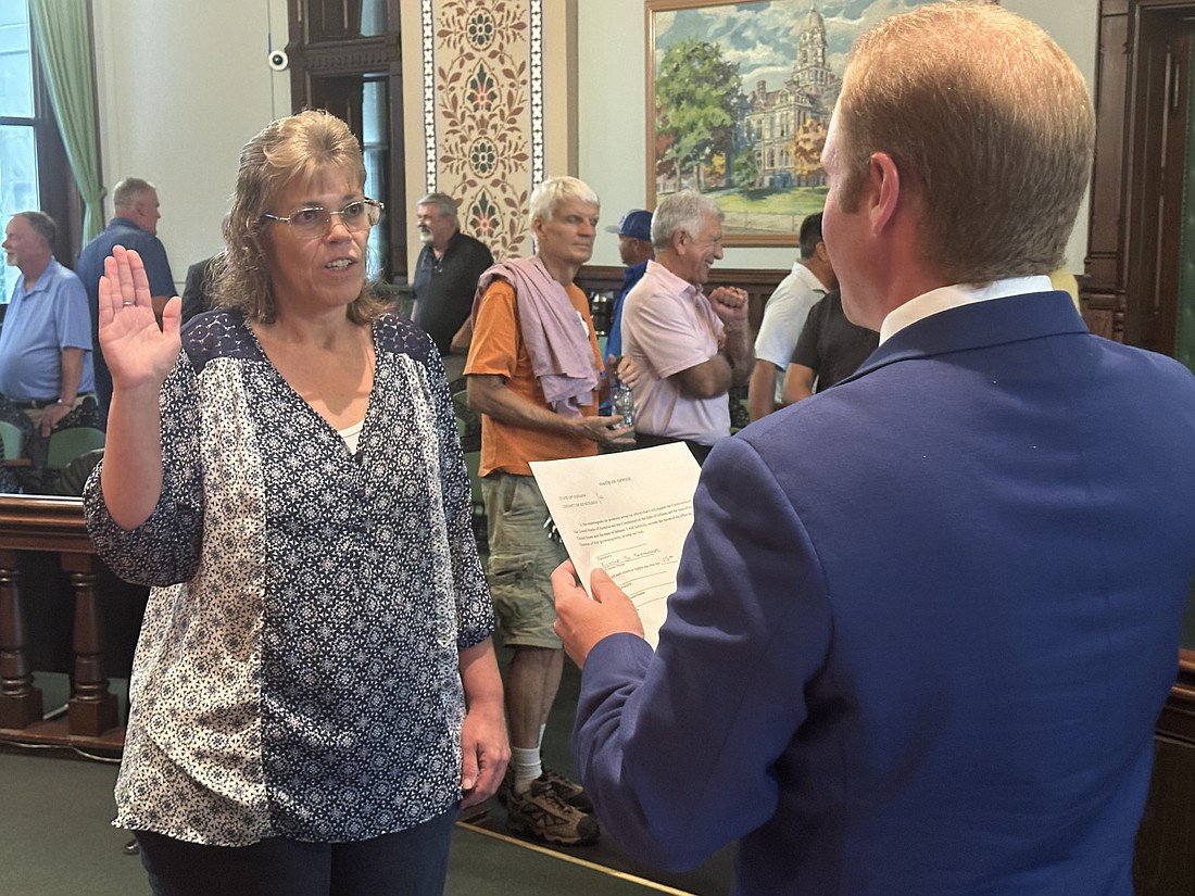 Alyssa Schmucker (L) is given the oath of office as the next Kosciusko County auditor from Kosciusko County Central Republican Committee Secretary Austin Rovenstine (R). She will take over from Rhonda Helser, who resigned effective Aug. 31. Photo by David Slone, Times-Union